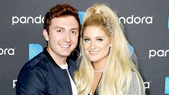 Daryl Sabara and Meghan Trainor holding one of their children.
