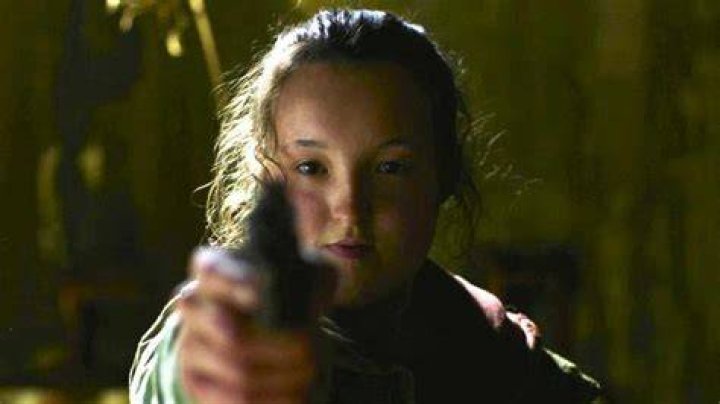 Ellie (Bella Ramsey) pointing a rifle